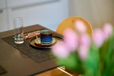a table with a cup and a plate and a glass at Villa Terlanen in Overijse