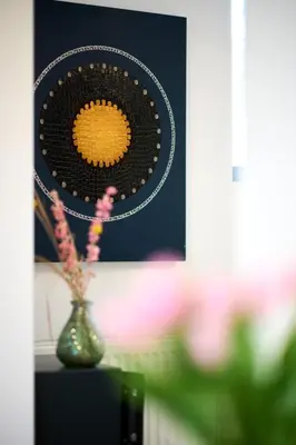 a vase with flowers on a table with a picture at Villa Terlanen in Overijse