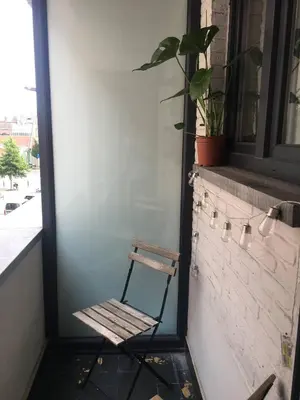 a chair sitting on a porch next to a window at Appartement op top locatie in Antwerpen in Antwerp