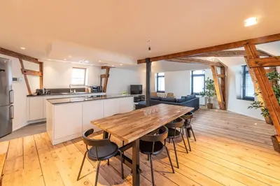 a kitchen and dining room with a wooden table and chairs at Spacious modern appartments in the heart of Brussels in Brussels