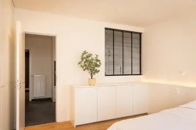 a bedroom with white cabinets and a window at Spacious modern appartments in the heart of Brussels in Brussels