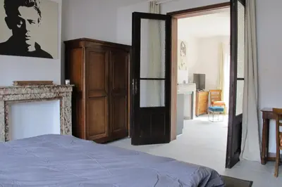 a bedroom with a bed and a fireplace and a door at Brussels Downtown with terrace in Brussels
