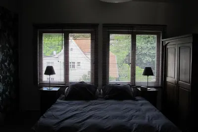 a bedroom with a bed with two lamps and two windows at Brussels Downtown with terrace in Brussels
