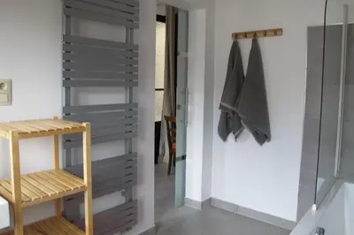 a bathroom with a glass shower door and a wooden stool at Brussels Downtown with terrace in Brussels