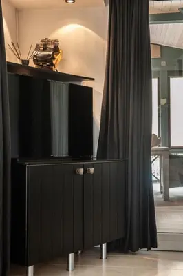 a black cabinet with a tv on top of it at Prachtige chalet Wabi Sabi aan het water! in Geel