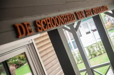 a sign for a classroom that says die schooled first few students at Prachtige chalet Wabi Sabi aan het water! in Geel