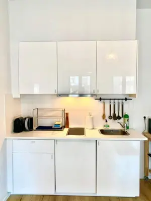 a white kitchen with white cabinets and a sink at Cozy Apartment in Antwerpen Centraal in Antwerp