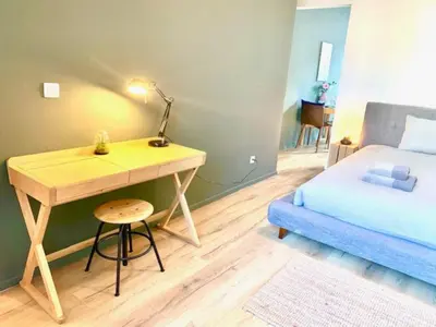 a bedroom with a desk and a bed and a bed and a table at Cozy Apartment in Antwerpen Centraal in Antwerp