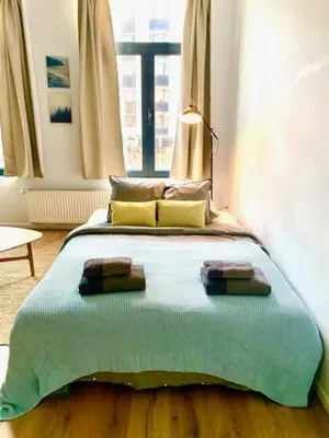 a bed with two towels on it in a room at Cozy Apartment in Antwerpen Centraal in Antwerp