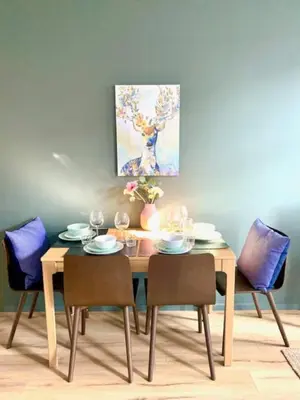 a dining room table and chairs with a painting on the wall at Cozy Apartment in Antwerpen Centraal in Antwerp