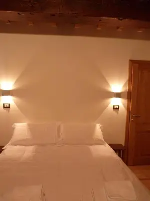 a bedroom with a white bed with two lights on the wall at L'Auberge de l'éclipse in Brussels