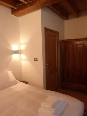 a bedroom with a white bed and a wooden door at L'Auberge de l'éclipse in Brussels