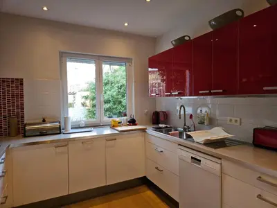 a kitchen with white cabinets and a window at Modern duplex with garden in Brussels