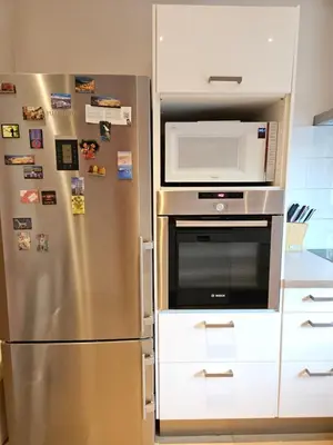 a kitchen with a stainless steel refrigerator and a microwave at Modern duplex with garden in Brussels