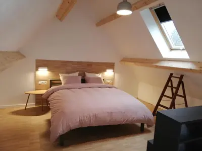 a bedroom with a bed and a desk and a window at Noest in Destelbergen