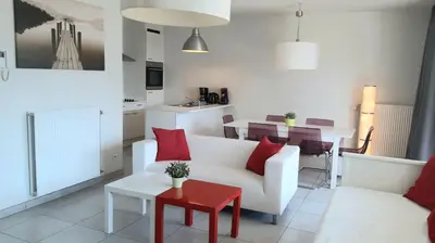 a living room with a white couch and a red table at 19 Brussels Expo in Wemmel