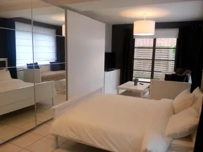 a bedroom with a white bed and a mirror at 19 Brussels Expo in Wemmel