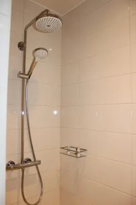 a shower with a shower head in a bathroom at B&B 't Mjeels Pierke in Meerle