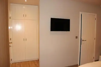 a bedroom with a flat screen tv on a wall at B&B 't Mjeels Pierke in Meerle