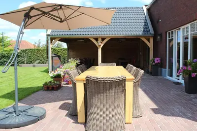 a table and chairs with an umbrella on a patio at B&B 't Mjeels Pierke in Meerle