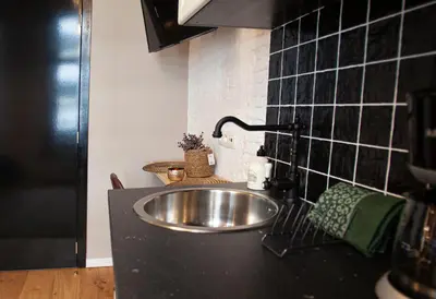 a kitchen sink in a black counter top at Luxury Suites Meir by Rikas Hotels in Antwerp