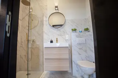a bathroom with a toilet and a sink and a mirror at Luxury Suites Meir by Rikas Hotels in Antwerp