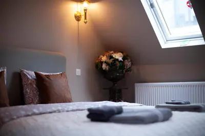 a bedroom with a bed with a vase of flowers at Luxury Suites Meir by Rikas Hotels in Antwerp