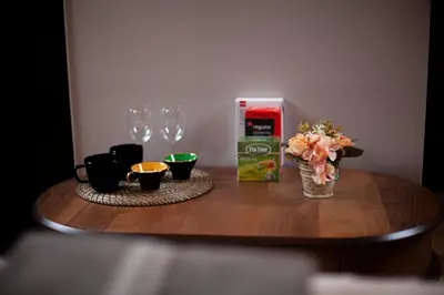a table with wine glasses and a vase of flowers at Luxury Suites Meir by Rikas Hotels in Antwerp