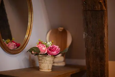 a vase with flowers on a table in front of a mirror at Luxury Suites Meir by Rikas Hotels in Antwerp