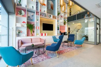 a waiting room with chairs and a couch and a tv at B&B HOTEL Gent Centrum in Ghent
