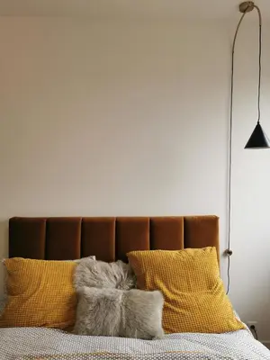 a bedroom with a bed with yellow and white pillows at The Penthouse, oasis of light and inspiration in Antwerp