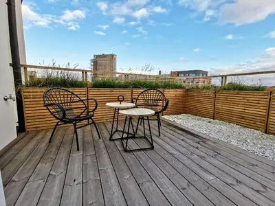 a patio with two chairs and a table on a deck at The Penthouse, oasis of light and inspiration in Antwerp