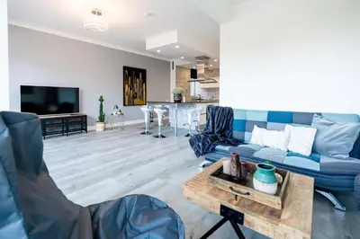 a living room with a blue couch and a table at Casa Plantin with parking place at the beautiful city park! in Antwerp
