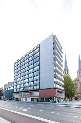 a large glass building with a street in front of it at Casa Plantin with parking place at the beautiful city park! in Antwerp