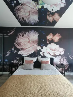a bedroom with a large bed with flowers on the wall at Casa Plantin with parking place at the beautiful city park! in Antwerp