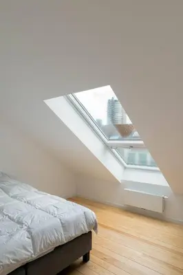 an attic bedroom with a bed and a window at Top Floor New Duplex Stunning View In Trendy St Gilles in Brussels