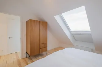 a bedroom with a bed and a window at Top Floor New Duplex Stunning View In Trendy St Gilles in Brussels