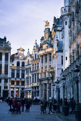 a group of people walking on a street in front of buildings at Holiday Inn Express Brussels-Grand-Place by IHG in Brussels