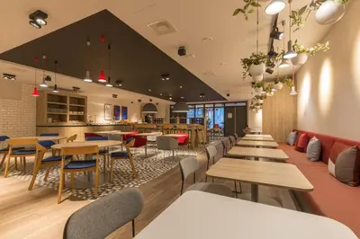 a restaurant with tables and chairs and a bar at Holiday Inn Express Brussels-Grand-Place by IHG in Brussels