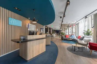 a lobby with a counter and chairs and tables at Holiday Inn Express Brussels-Grand-Place by IHG in Brussels