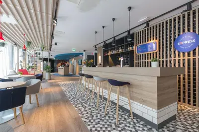 a bar in a restaurant with chairs and tables at Holiday Inn Express Brussels-Grand-Place by IHG in Brussels