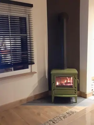 a green stove in a room with a window at Vélo 94 in Geel