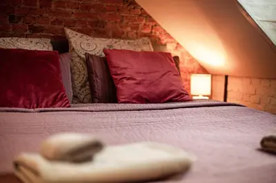 a bedroom with a bed with red pillows at Luxury Suites Historic Center by Rikas Hotels in Antwerp