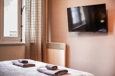 two towels on a bed with a television on a wall at Luxury Suites Historic Center by Rikas Hotels in Antwerp