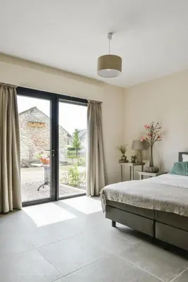 a bedroom with a bed and a large sliding glass door at B&B O Chocolat Cho in Sint-Pieters-Leeuw