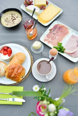a table with plates of food and a cup of coffee at B&B O Chocolat Cho in Sint-Pieters-Leeuw
