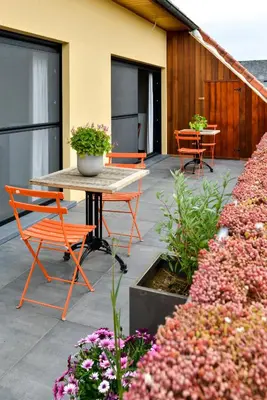 a patio with a table and chairs and flowers at B&B O Chocolat Cho in Sint-Pieters-Leeuw