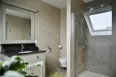 a bathroom with a shower and a toilet and a sink at B&B O Chocolat Cho in Sint-Pieters-Leeuw