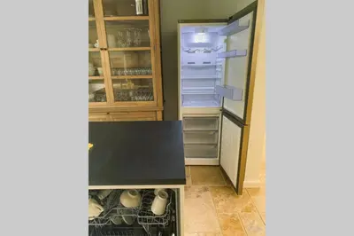an empty kitchen with an open refrigerator at Gastenhuis prachtige Historische Vierkant Hoeve in Broechem