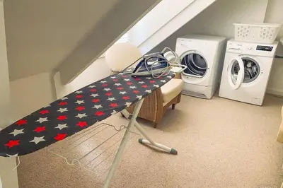 a washing machine and a table in a laundry room at Gastenhuis prachtige Historische Vierkant Hoeve in Broechem